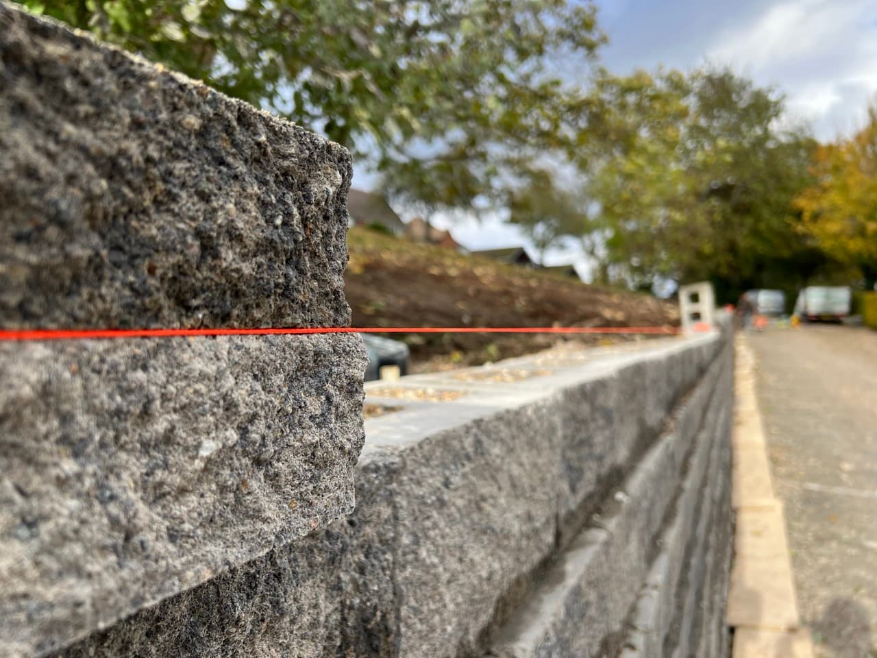 Grass Barbers professional hard landscaping team installing reinforced retaining wall and hardstanding surface in Surrey